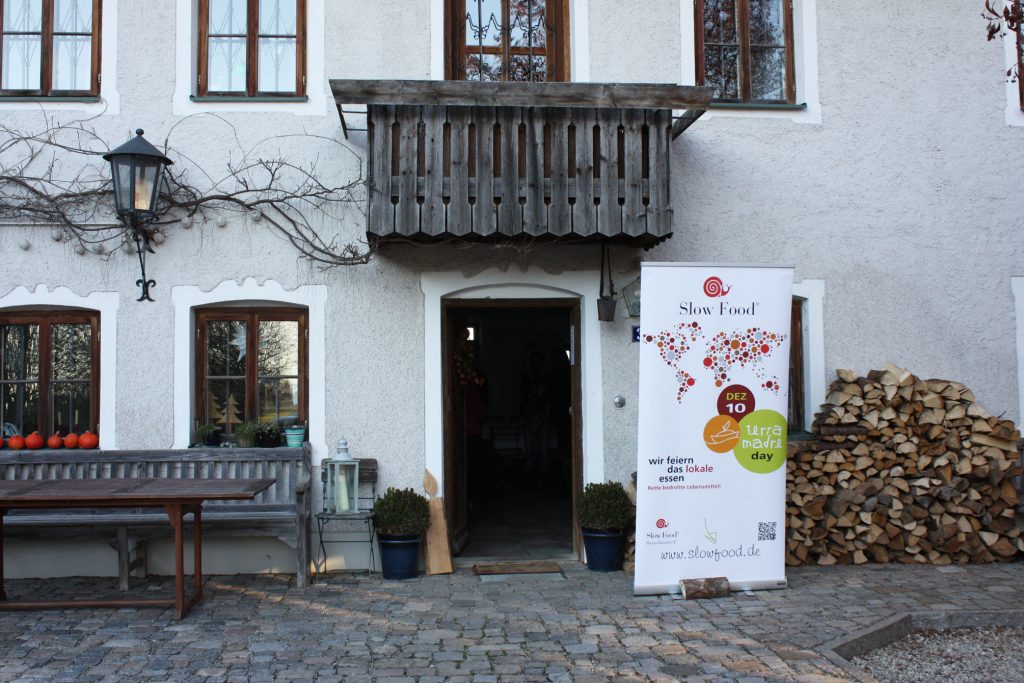 Eingang zum Bauernhaus von Julia Reimann und Stefan Schmutz im Chiemgau. Vor der Tür steht das Slow Food Plakat
